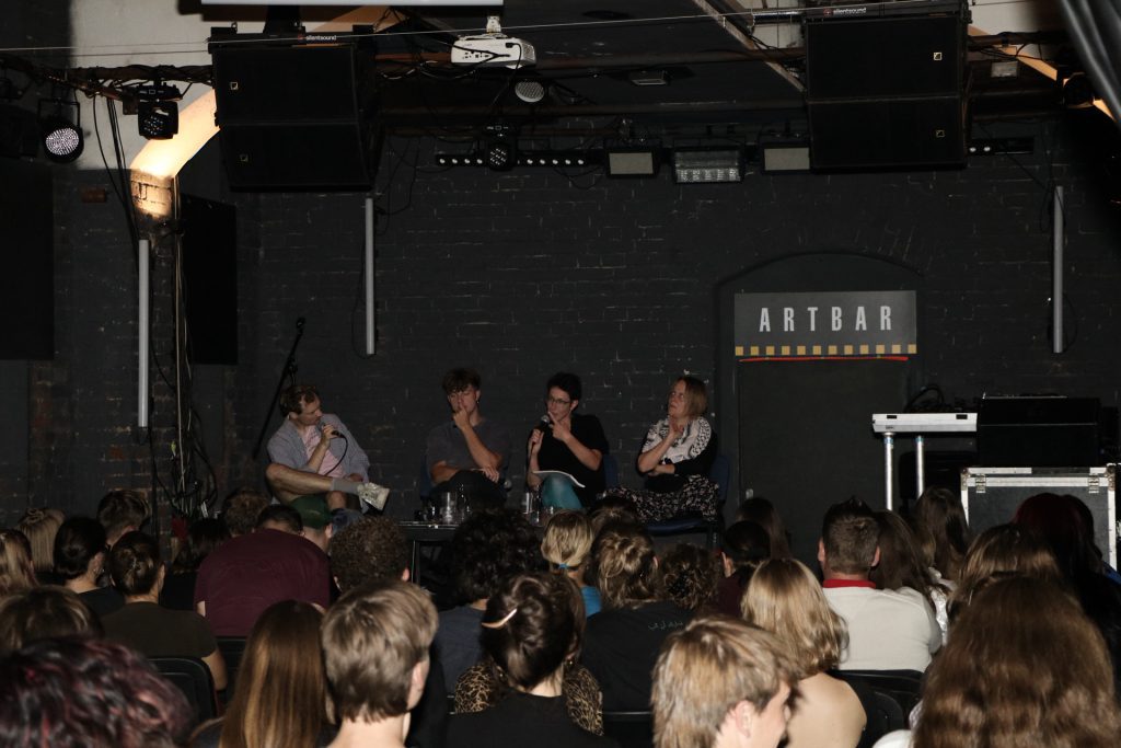 Publikum a diskutující v podzemních prostorách Artbaru