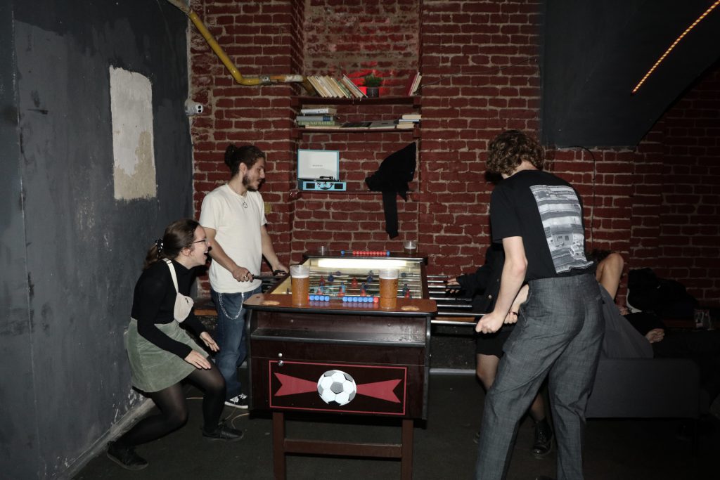 Čtyři lidé hrají stolní fotbal